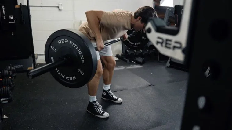 Our tester using the REP Fitness Black Bumper Plates for a bent-over row.