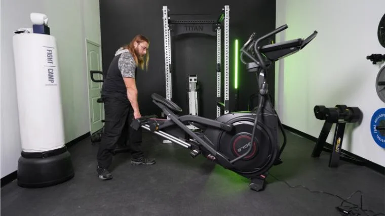 A person moving the Sole E25 elliptical.