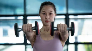 A person performs a dumbbell front raise.