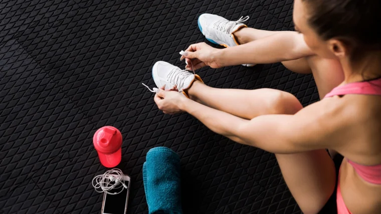 A person tying her shoelace.