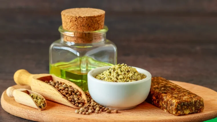 Hemp seeds, hemp oil and a bowl full of shelled hemp seeds.