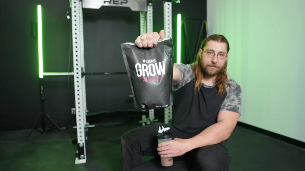xwerks-grow-protein-full-view-holding-bag-front-of-bag-visible BarBend tester sampling XWERKS Grow protein.