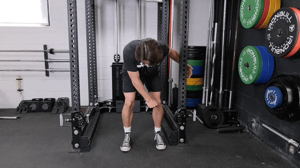 A person demonstrating the cable single-arm bent-over flye exercise.