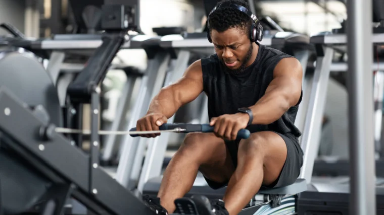A fit person working out in the gym on a rowing machine.