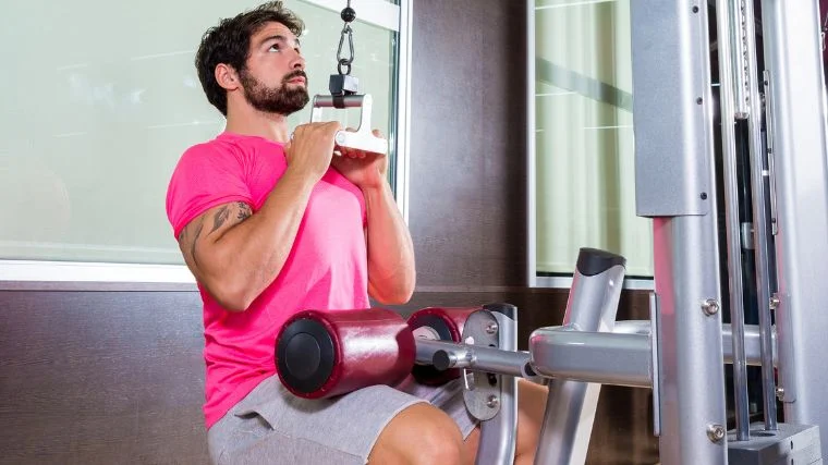 A gymgoer performing neutral-grip pulldowns.