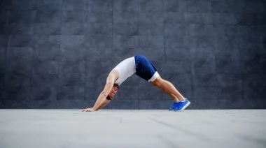 Side view of a fit person doing inchworms exercise.