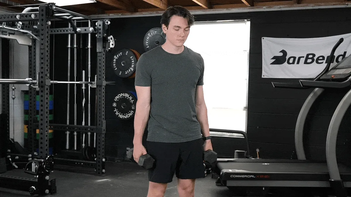 BarBend's Jake Herod  performing the dumbbell wrist curl exercise.