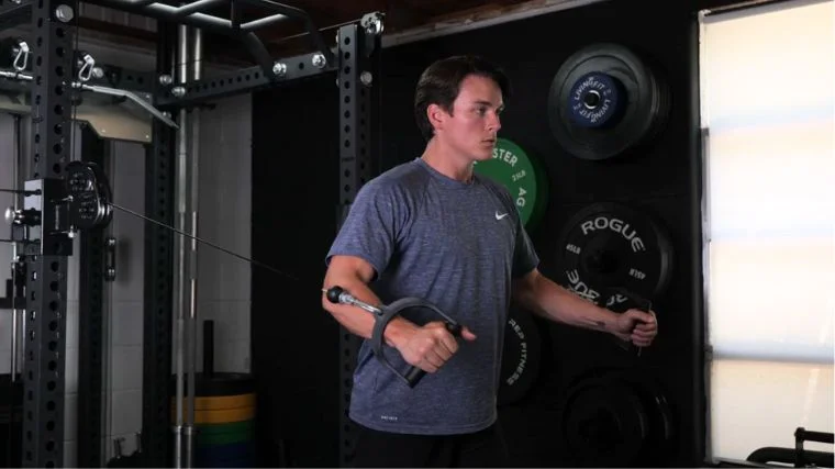 A person doing the cable flye workout.
