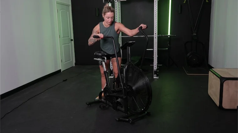 A BarBend tester getting onto the Assault Fitness AssaultBike Classic