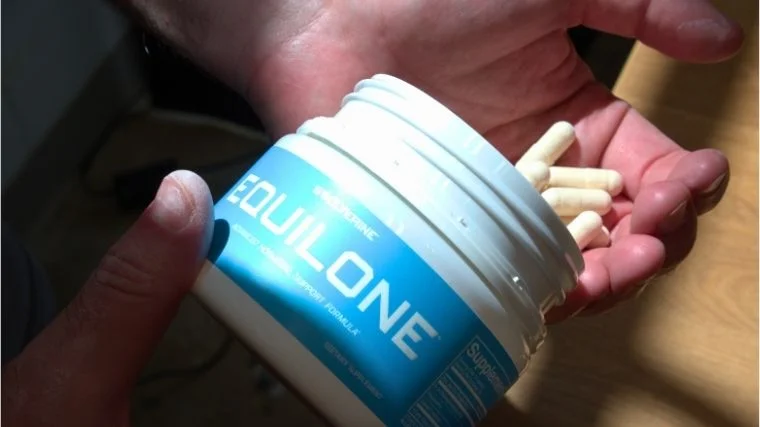 A person pouring Equilone® capsules into their hand