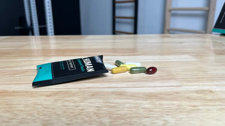 onnit-total-human-open-pack-on-table Onnit Total Human multivitamins spilled out of the pack on a table.