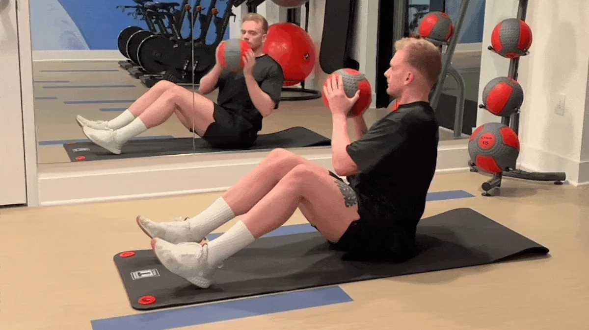 A person performing the Russian twist exercise.