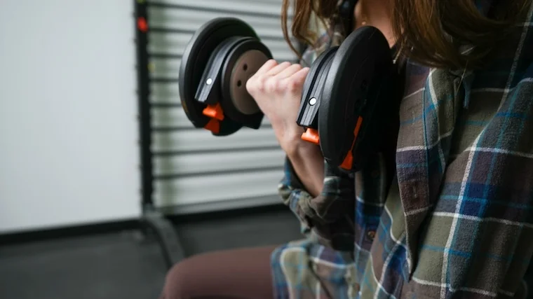 Our tester curling the NordicTrack Select-A-Weight Dumbbell