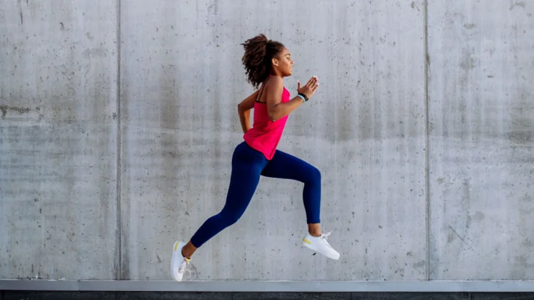A fit person doing the lunge exercise outdoors.