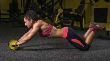An athlete doing the ab wheel workout.
