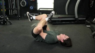 A person doing the figure four piriformis stretch as part of their post-run stretch.