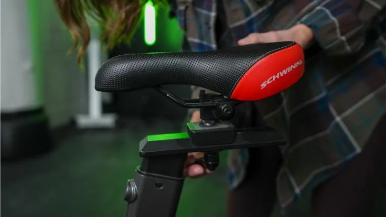 Our BarBend tester adjusting the seat on the Schwinn IC4.