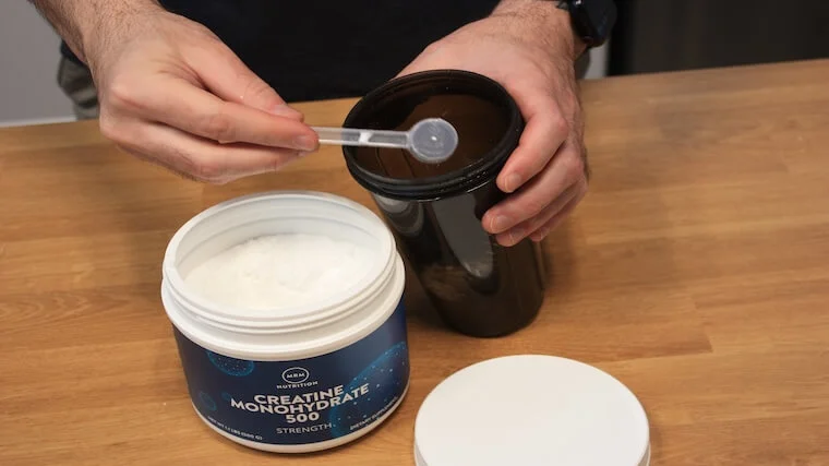 Our tester adding a scoop of MRM Nutrition Creatine to their shaker bottle