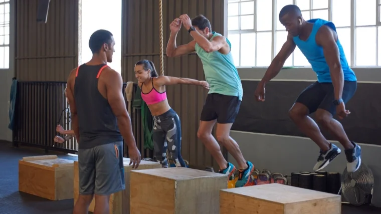 Pumped young athletes doing box jumps.